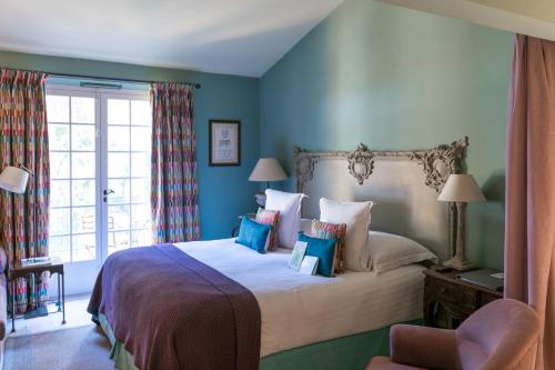 a bedroom with a large bed with blue walls at Hôtel Villa Marie Saint Tropez in Saint-Tropez