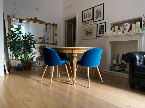 jadalnia z drewnianym stołem i niebieskimi krzesłami w obiekcie Bohemian House w Mediolanie