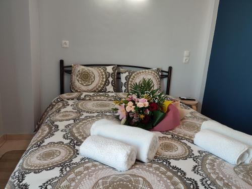 - un lit avec des serviettes et un vase de fleurs dans l'établissement Dream House Ioannina, à Ioannina