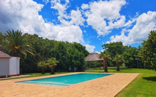 a swimming pool in the yard of a house at Clivia Lodge in Vanderbijlpark