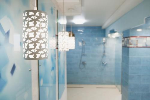 a bathroom with a shower and a light fixture at Готель Хутір in Malyye Khutora