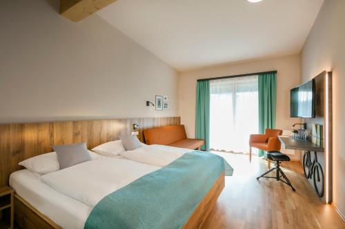 マリアツェルにあるJUFA Hotel Erlaufseeの大型ベッドとテレビが備わるホテルルームです。