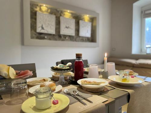 a dining room table with plates of food and candles at B&B Il Piccolo Principe room and breakfast in Bieno