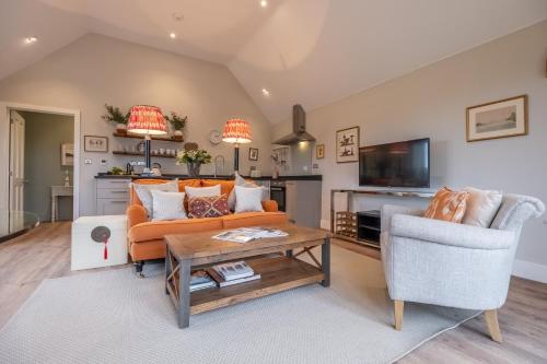 a living room with a couch and a table at Elegant luxurious cottage - The Dove House in Ipswich