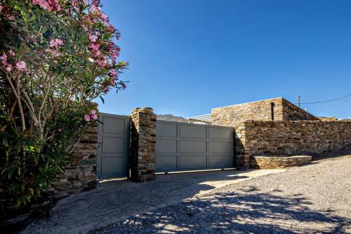a garage with a gate and a stone wall at m.houses1 in Agios Romanos
