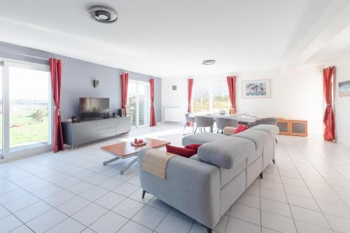 ein Wohnzimmer mit Sofa und Tisch in der Unterkunft PENN AR ROZ - Grande maison familiale proche mer in Saint-Pabu