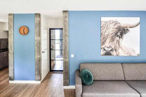 a living room with a couch and a picture of a cow at Tof wellness huis, alles nieuw, gelegen bij meer. in Ewijk