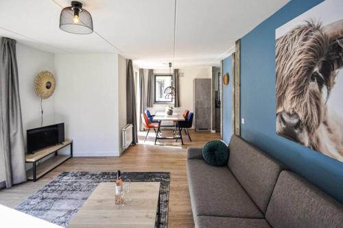 a living room with a couch and a horse on the wall at Tof wellness huis, alles nieuw, gelegen bij meer. in Ewijk