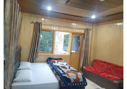 a small room with a bed and a window at Hotel Prakriti in Gangotri