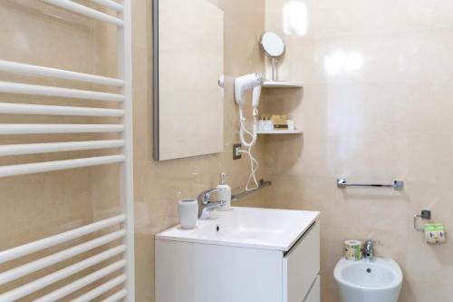 a white bathroom with a sink and a mirror at A casa dei miei in San Pietro Vernotico