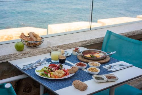 a table with plates of food on a table with a view of the ocean at Akotika boutique in ‘Akko