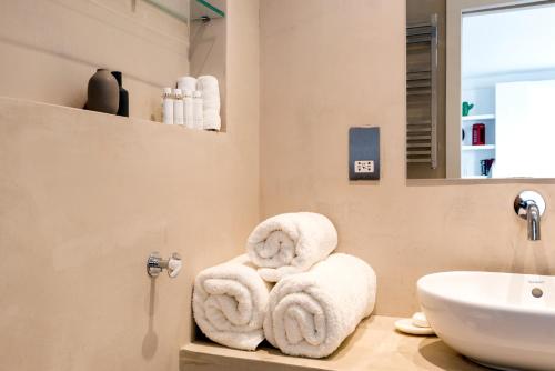 łazienka z ręcznikami na blacie obok umywalki w obiekcie Brand new studio flat in the heart of Notting Hill w Londynie