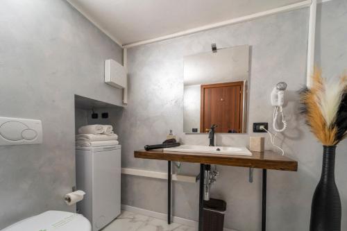 a bathroom with a sink and a toilet and a mirror at Aurelia Luxury - Piazza delle Erbe in Verona