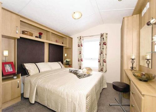 a bedroom with a large bed and a window at Lakeside Holiday Park in Burnham on Sea