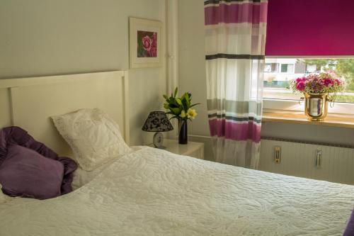 ein Schlafzimmer mit einem weißen Bett und einem Fenster in der Unterkunft FeWo 122, Hanseat II in Grömitz