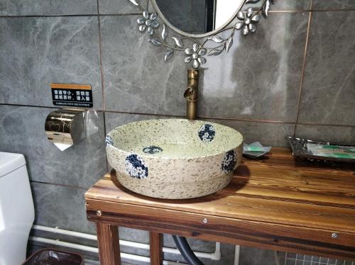 lavabo en una mesa de madera en el baño en Billina Private Boutique Garden Cottage en Huairou