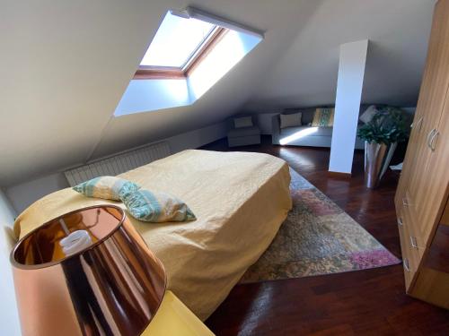 sypialnia na poddaszu z łóżkiem i oknem w obiekcie Angiolina w mieście Baveno
