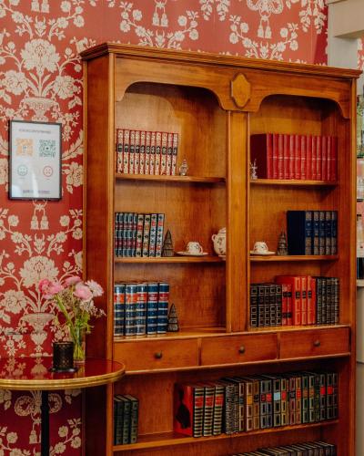 a wooden book shelf filled with books at Hotel Le Grimaldi by Happyculture in Nice