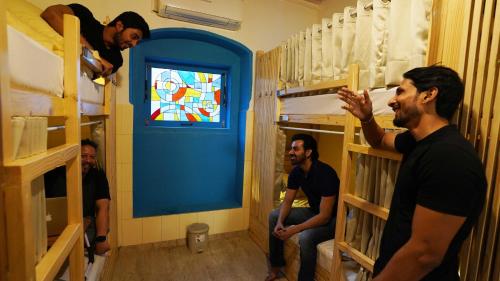 a group of men in a room with bunk beds at GoSolo Stays Bandra Hostel in Mumbai