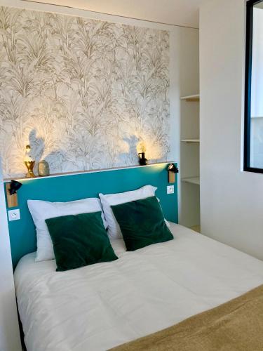 - un lit avec une tête de lit bleue et 2 oreillers verts dans l'établissement La Belle Vue Appartement 2 personnes Vue port, à Dieppe