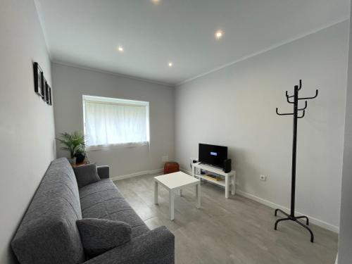 a living room with a couch and a tv at Happy House Barreiro in Barreiro