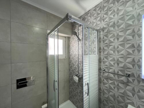 W łazience znajduje się prysznic ze szklanymi drzwiami. w obiekcie Happy House Barreiro w mieście Barreiro