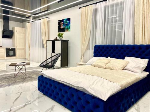 ein Schlafzimmer mit einem großen blauen Bett in einem Zimmer in der Unterkunft GRAND APARTMENT BALTEZERS in Riga