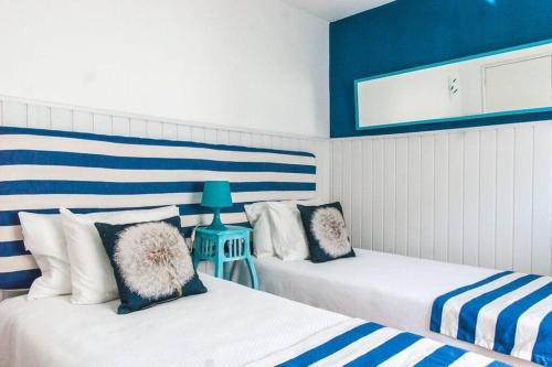 two beds in a room with blue and white at Casa da Ti´ Milia in Encarnação