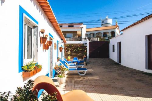 a patio with blue chairs on a house at Casa da Ti´ Milia in Encarnação