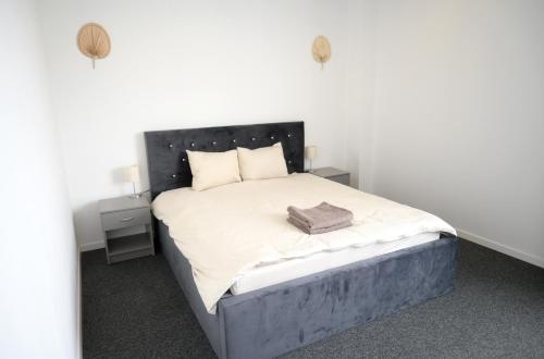a bedroom with a bed with a black headboard at Luana Airport Apartments #7 in Otopeni