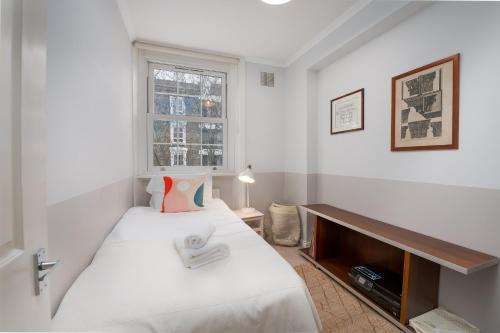 - une petite chambre avec un lit et une fenêtre dans l'établissement Fantastic two bedroom apartment in vibrant Kings Cross by UnderTheDoormat, à Londres
