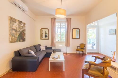 a living room with a couch and a table at Le Mas, maison au charme provençale idéalement située entre mer et vignes in Hyères