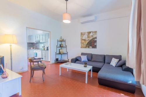 a living room with a couch and a table at Le Mas, maison au charme provençale idéalement située entre mer et vignes in Hyères