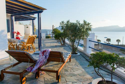 a patio with chairs and a table on top of a house at AEGEA MILOS in Adamas