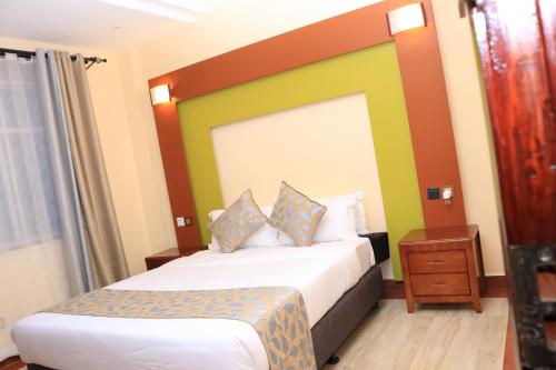 a hotel room with a bed with a colorful headboard at Dallas Premiere Hotel in Kisii