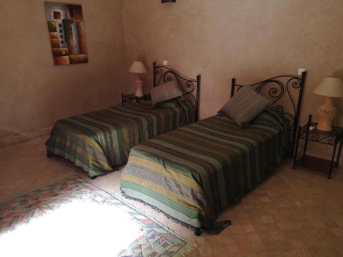 dos camas sentadas una al lado de la otra en un dormitorio en Riad Ain Khadra, en Taroudant