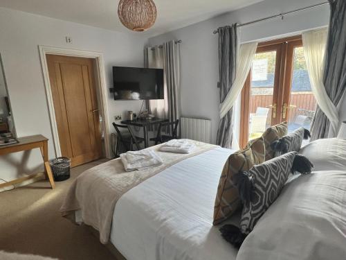 a bedroom with a large bed and a window at The Gower Hotel in Swansea