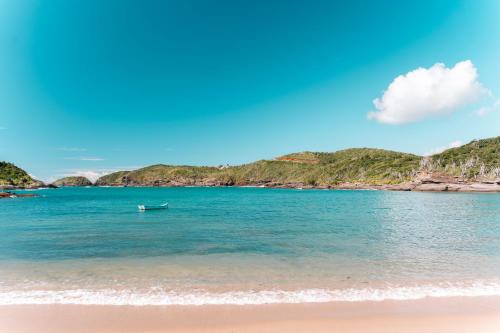 a beach with a boat in the water at Le Village Boutique Hotel in Búzios