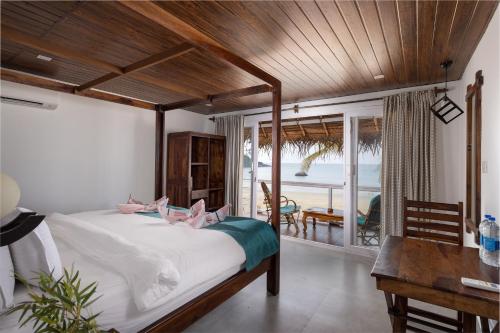 um quarto com uma cama com duas pessoas deitadas sobre ela em The Shore beach resort Palolem em Canacona