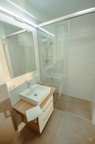 a white bathroom with a sink and a shower at Mein Appartement Nr.9 in Planneralm