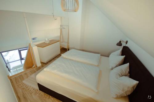 ein kleines Schlafzimmer mit einem Bett mit weißer Bettwäsche und Kissen in der Unterkunft Mein Appartement Nr.9 in Planneralm