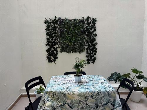a table with plants on a wall with a table with chairs at Confort y relax centro in Valencia