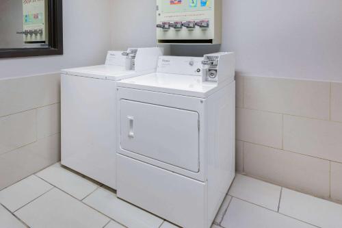 y baño con lavadora y secadora blancas. en Super 8 by Wyndham League City Kemah Area en League City