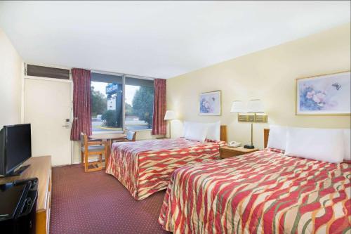 a hotel room with two beds and a flat screen tv at Bristol Parkway inn in Bristol
