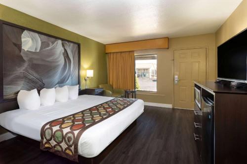 a hotel room with a large bed and a flat screen tv at Super 8 by Wyndham NAU/Downtown Conference Center in Flagstaff