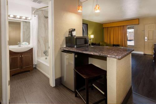 a bathroom with a sink and a counter with a microwave at Super 8 by Wyndham NAU/Downtown Conference Center in Flagstaff