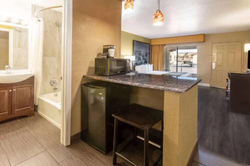a kitchen with a counter with a microwave and a sink at Super 8 by Wyndham NAU/Downtown Conference Center in Flagstaff