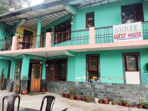 a guest house with two chairs in front of it at Shree Guest House in McLeod Ganj