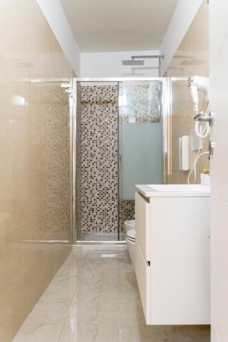 a white bathroom with a shower and a sink at A casa dei miei in San Pietro Vernotico