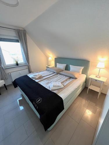 a bedroom with a large bed with two tables and a window at Ferien-Whg Möwe nahe Steinhuder Meer mit Garten und Balkon in Hagenburg
